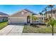 A beautiful single-Gathering home featuring a two-car garage, arched entryway, and lush landscaping at 11414 Weston Course Loop, Riverview, FL 33579