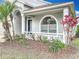 The front porch is adorned with white columns, vibrant greenery, and an arched window at 11414 Weston Course Loop, Riverview, FL 33579