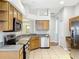 Bright kitchen with stainless steel appliances, oak cabinetry and view to another room at 11414 Weston Course Loop, Riverview, FL 33579