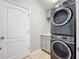 Laundry room with stacked washer and dryer, white door and cabinet with counter at 11414 Weston Course Loop, Riverview, FL 33579