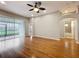 Spacious living room with hardwood floors, ceiling fan, and access to outdoor patio at 11414 Weston Course Loop, Riverview, FL 33579