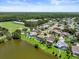An aerial view shows beautiful lakeside homes in a residential community with lush landscaping and blue skies at 11519 Glenmont Dr, Tampa, FL 33635