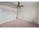 Carpeted bedroom with ceiling fan, closet, and door to the landing at 11519 Glenmont Dr, Tampa, FL 33635