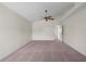 This carpeted bedroom has a fan, neutral walls, and a view to the hallway at 11519 Glenmont Dr, Tampa, FL 33635
