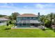 Rear exterior of home featuring a large screened-in patio and pool area, surrounded by a lush green lawn and trees at 11519 Glenmont Dr, Tampa, FL 33635