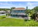 Rear exterior of home featuring a large screened-in patio and pool area, surrounded by lush green lawns and landscaping at 11519 Glenmont Dr, Tampa, FL 33635