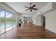 Inviting living room with hardwood floors, ceiling fan, and sliding doors to the pool and lake at 11519 Glenmont Dr, Tampa, FL 33635