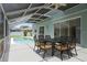 Outdoor dining on the screened in patio area with an outdoor dining set next to the beautiful pool at 11519 Glenmont Dr, Tampa, FL 33635