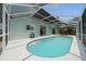 Enclosed pool with clear blue water and screened in patio area with seating, perfect for outdoor entertaining at 11519 Glenmont Dr, Tampa, FL 33635