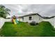 Large fenced backyard with a play set and lush lawn, perfect for entertaining or relaxing in the outdoors at 1155 Lawnview Ter, New Port Richey, FL 34655