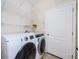 Laundry room with washer, dryer, white wire shelving, and a door at 1155 Lawnview Ter, New Port Richey, FL 34655