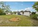 Expansive backyard features a brick-lined planting area, set against a partly cloudy sky at 11705 Ibis Ln, Port Richey, FL 34668