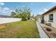 Side yard with healthy grass, stone, rock features, mature trees and a view of the property line at 11705 Ibis Ln, Port Richey, FL 34668