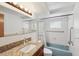 Bright bathroom with a granite vanity, blue tub, and updated fixtures at 11705 Ibis Ln, Port Richey, FL 34668