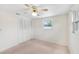 Bedroom featuring carpet flooring, a ceiling fan and a closet with louvered doors at 11705 Ibis Ln, Port Richey, FL 34668