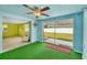 Green-carpeted lanai with ceiling fan and sliding glass doors offers bright space with backyard views at 11705 Ibis Ln, Port Richey, FL 34668