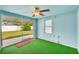Enclosed lanai boasts unique green carpet, light blue walls, fan and sliding glass doors to the yard at 11705 Ibis Ln, Port Richey, FL 34668