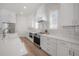 Detailed kitchen with stainless steel appliances, white cabinetry, and a white tile backsplash at 1550 48Th N Ave, St Petersburg, FL 33703