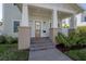 Inviting front porch with elegant columns and a stylish entrance, framed by lush landscaping at 1550 48Th N Ave, St Petersburg, FL 33703