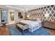 Main bedroom suite featuring patterned wallpaper, wood floors, and a large bed at 1725 Trailhead Ln, Zephyrhills, FL 33541