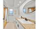 Bathroom with natural stone surfaces, modern vanity, and shower-tub combo at 1810 Pine Hill Dr, Safety Harbor, FL 34695