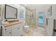 Bathroom featuring a marble vanity, glass-enclosed shower, and direct access to the pool area at 1810 Pine Hill Dr, Safety Harbor, FL 34695