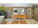 Modern bathroom boasts dual sinks, wood cabinet, tiled shower, and stylish decor at 1810 Pine Hill Dr, Safety Harbor, FL 34695