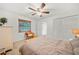 Bright, modern bedroom featuring neutral walls, a ceiling fan, and a double closet for ample storage at 1810 Pine Hill Dr, Safety Harbor, FL 34695