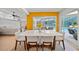 Dining room with bright yellow accent wall looking out to pool and patio at 1810 Pine Hill Dr, Safety Harbor, FL 34695