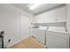 Functional laundry room equipped with a washer, dryer, sink, and ample storage cabinets at 1810 Pine Hill Dr, Safety Harbor, FL 34695