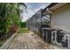 Outdoor pool area with an enclosed screened-in lanai, lush foliage, and a brick-paved patio at 1810 Pine Hill Dr, Safety Harbor, FL 34695