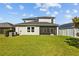 The backyard features a well-maintained lawn, a screened-in porch, and a view of the home's exterior at 19309 Prairie Tree Pl, Tampa, FL 33647
