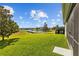 Enjoy a beautiful backyard view featuring a lush green lawn and a tranquil pond in the distance at 19309 Prairie Tree Pl, Tampa, FL 33647