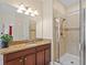 Bathroom vanity with granite countertops, dark wood cabinets, and a glass-enclosed shower at 19309 Prairie Tree Pl, Tampa, FL 33647