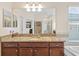 Bathroom vanity with granite countertops, dual mirrors, and a separate bathtub at 19309 Prairie Tree Pl, Tampa, FL 33647