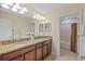 Bathroom featuring a double vanity with granite countertops and an adjacent shower at 19309 Prairie Tree Pl, Tampa, FL 33647