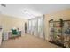 Well-lit bedroom with natural light, neutral walls, and a desk with a vanity and display cabinet at 19309 Prairie Tree Pl, Tampa, FL 33647