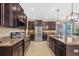 Modern kitchen boasts stainless steel appliances, granite countertops, dark cabinetry, and an island with seating at 19309 Prairie Tree Pl, Tampa, FL 33647