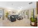 Bright living room features tile flooring, large windows with curtains, and a comfortable black reclining sofa at 19309 Prairie Tree Pl, Tampa, FL 33647