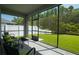 Inviting screened patio with comfortable seating and a view of the lush green backyard at 19309 Prairie Tree Pl, Tampa, FL 33647