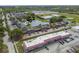 An aerial view of an apartment complex with a pool, pond, and shopping center nearby at 200 Country Club Dr # 308, Largo, FL 33771