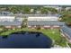 Aerial view of apartment buildings situated by a large pond with a bench and green space at 200 Country Club Dr # 308, Largo, FL 33771