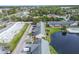 An aerial view of an apartment complex situated next to a pond, street, and commercial buildings at 200 Country Club Dr # 308, Largo, FL 33771
