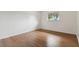 Neutral bedroom offers wood-look flooring, a window with a view, and a crisp, clean aesthetic at 200 Country Club Dr # 308, Largo, FL 33771