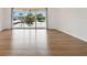 Open living room with beautiful wood flooring and large glass doors with views of the pond, and fountain at 200 Country Club Dr # 308, Largo, FL 33771