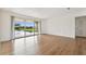 Living room with wood-look floors and sliding glass doors to a patio overlooking the peaceful pond and fountain at 200 Country Club Dr # 308, Largo, FL 33771