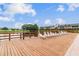 View of lounge chairs beside a pond and well-maintained apartments under a clear blue sky at 200 Country Club Dr # 308, Largo, FL 33771