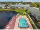 An aerial view of a pool with lounge chairs alongside a pond and apartment buildings at 200 Country Club Dr # 308, Largo, FL 33771