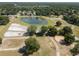 Aerial view of a horse property with white fences, barns, and a large community lake at 22304 Stillwood Dr, Land O Lakes, FL 34639