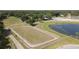 Aerial view of equestrian facility featuring an enclosed riding area, pond and mature trees at 22304 Stillwood Dr, Land O Lakes, FL 34639